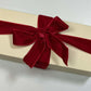 Beige gift box, filled with luxury mini candles with a red ribbon on a light background. 