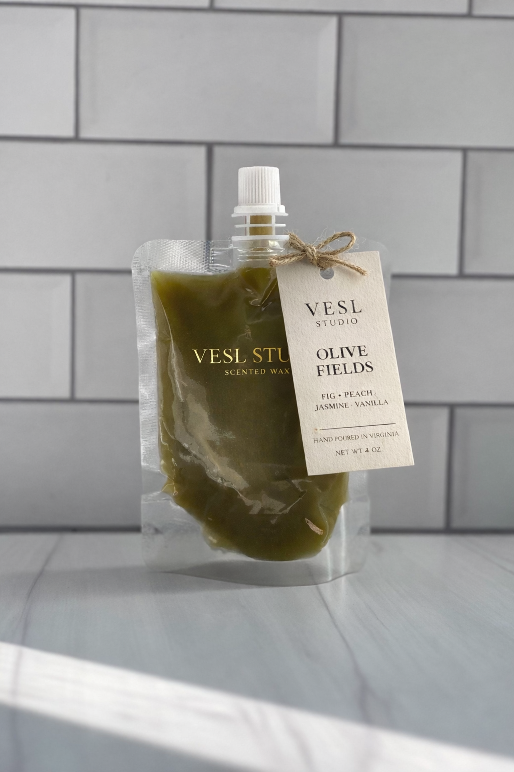 Vesl Studio olive fields squeeze wax melt with a label on a tiled background
